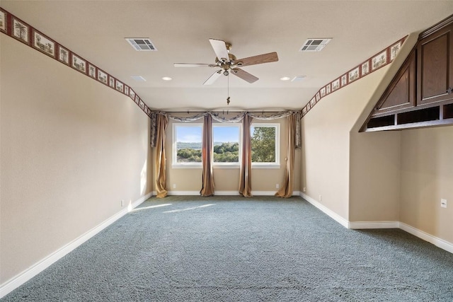 carpeted spare room with baseboards, visible vents, and ceiling fan