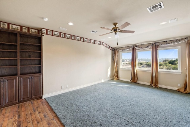 empty room with ceiling fan, visible vents, and baseboards