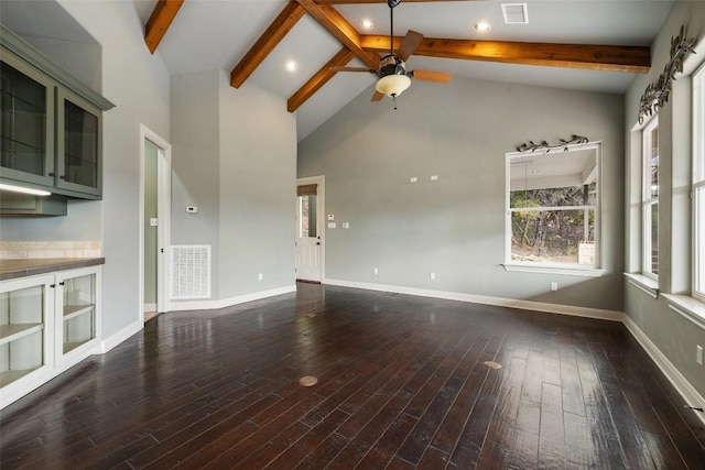 unfurnished living room featuring dark wood-style floors, beam ceiling, and visible vents