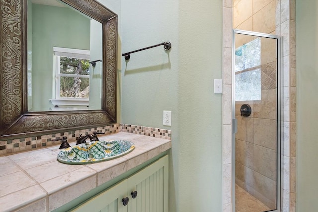 bathroom with a shower stall, decorative backsplash, and vanity