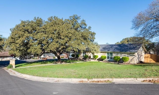 view of front facade featuring a front yard and fence