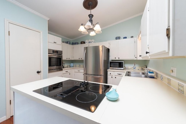 kitchen featuring appliances with stainless steel finishes, white cabinets, light countertops, and hanging light fixtures