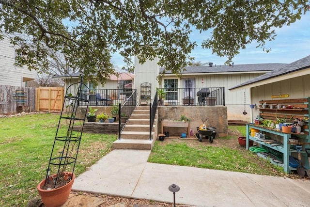 view of front of home with a front lawn and fence