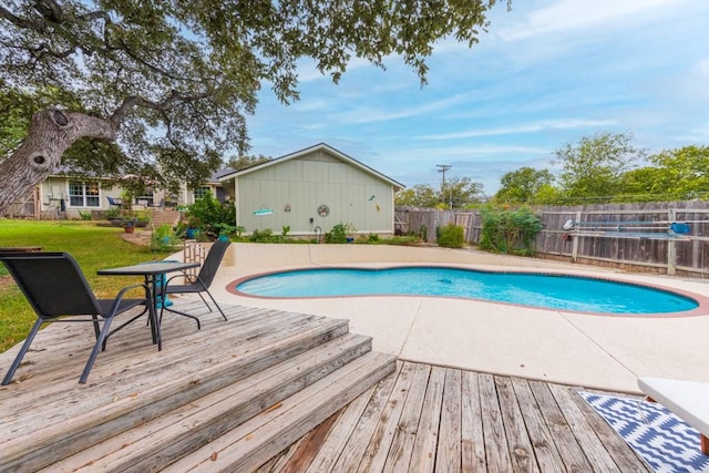 view of swimming pool featuring a fenced backyard, a wooden deck, and a fenced in pool