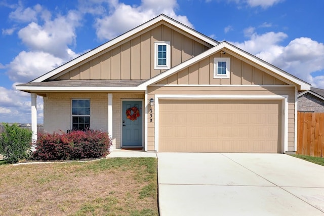 view of front facade featuring a garage, brick siding, fence, driveway, and board and batten siding