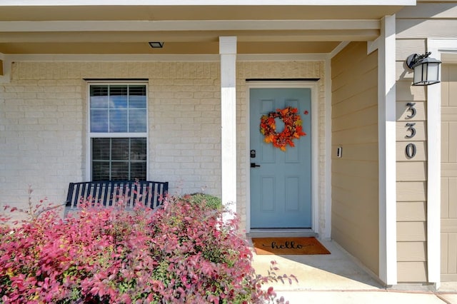 property entrance with a garage and brick siding