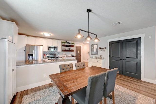 dining room featuring light wood finished floors and visible vents