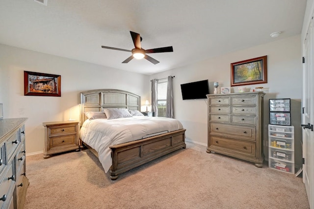 bedroom featuring light carpet, a ceiling fan, and baseboards