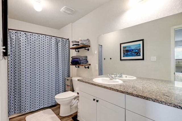 bathroom featuring toilet, visible vents, wood finished floors, and vanity