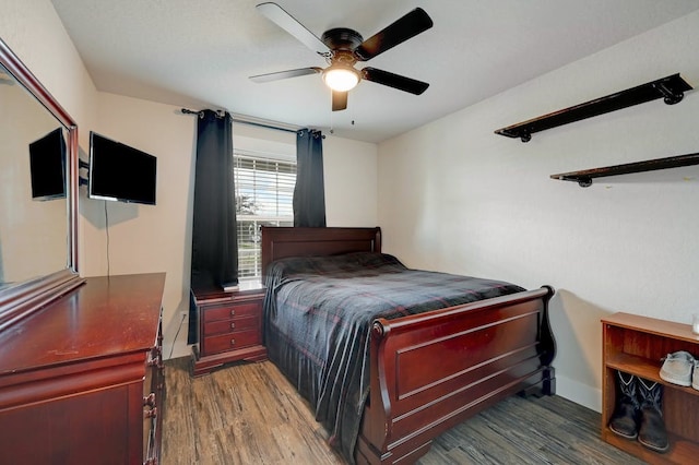 bedroom with baseboards, a ceiling fan, and dark wood-style flooring