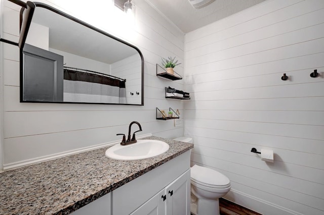 bathroom with toilet, vanity, and a shower with curtain