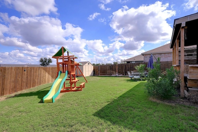 view of play area with a yard, a storage unit, and a fenced backyard