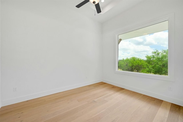 spare room featuring light wood-type flooring, baseboards, and a ceiling fan