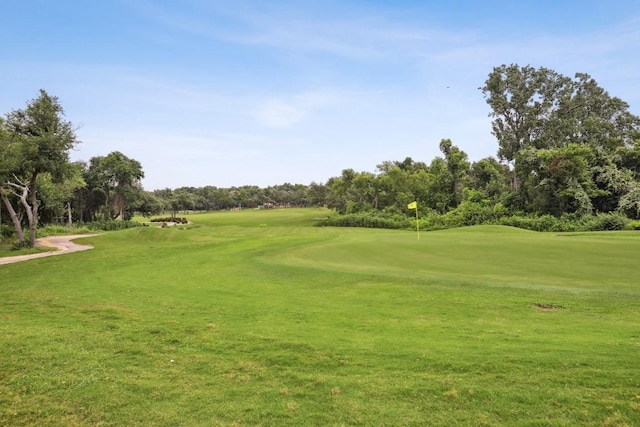view of community featuring view of golf course and a lawn