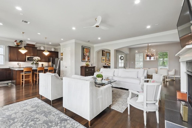 living area with a healthy amount of sunlight, visible vents, and dark wood finished floors