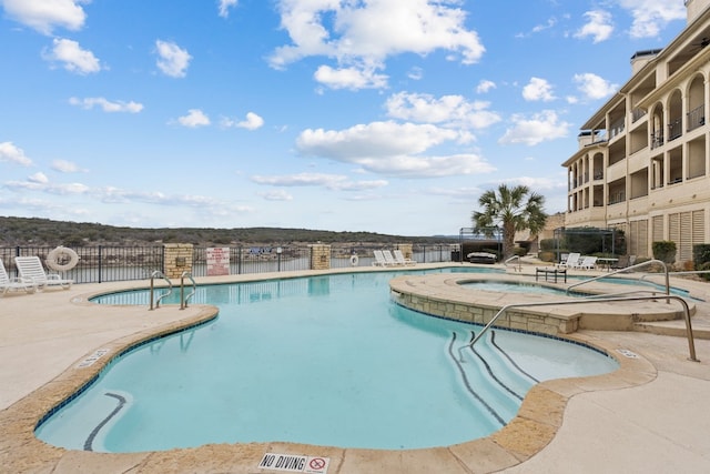 community pool featuring a community hot tub, a patio, and fence