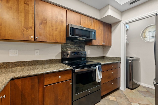 kitchen with stainless steel electric range, visible vents, brown cabinetry, dark stone counters, and baseboards