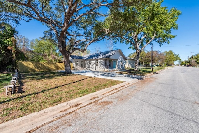 ranch-style house with fence, concrete driveway, and a front yard