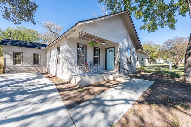 bungalow featuring a porch and fence