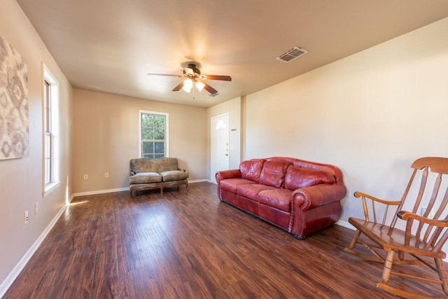 living area featuring ceiling fan, baseboards, visible vents, and dark wood finished floors