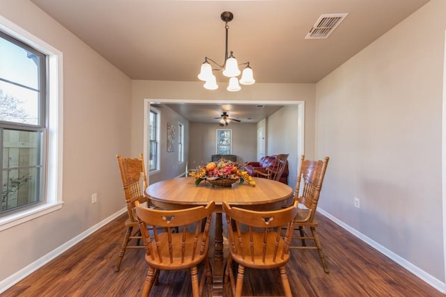 dining space featuring an inviting chandelier, baseboards, visible vents, and dark wood-style flooring