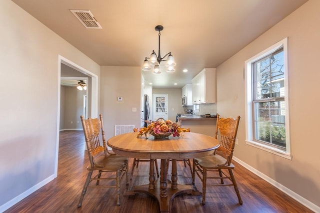 dining space with baseboards, visible vents, a chandelier, and dark wood-type flooring