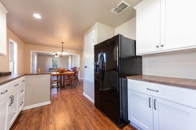 404 S Oak Ave, Luling, TX 78648 - kitchen with black refrigerator with ice dispenser, a chandelier, dark countertops, dark wood-type flooring, and white cabinetry