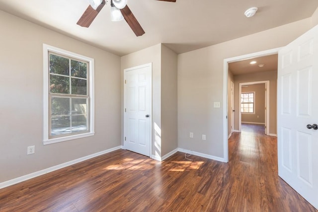 unfurnished bedroom with ceiling fan, baseboards, and dark wood-style flooring