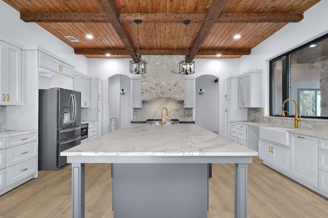 LOT34 Prancing Deer Ln, Johnson City, TX 78636 - kitchen with arched walkways, wooden ceiling, a spacious island, a sink, and refrigerator with ice dispenser