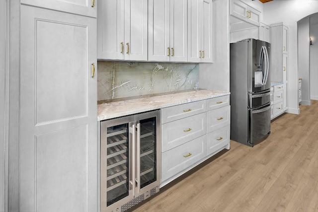 LOT34 Prancing Deer Ln, Johnson City, TX 78636 - kitchen with wine cooler, white cabinets, stainless steel refrigerator with ice dispenser, light stone countertops, and light wood finished floors
