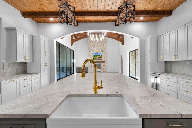 LOT34 Prancing Deer Ln, Johnson City, TX 78636 - kitchen featuring hanging light fixtures, light stone countertops, a kitchen island with sink, and a sink