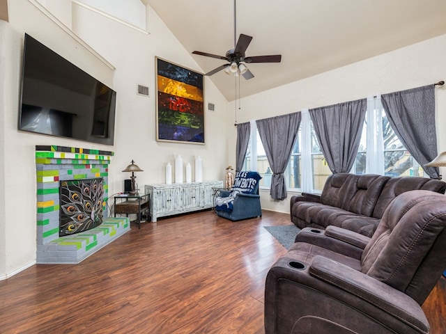 living room with dark wood-style floors, a ceiling fan, visible vents, and a wealth of natural light