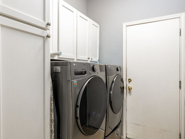 clothes washing area with cabinet space and independent washer and dryer