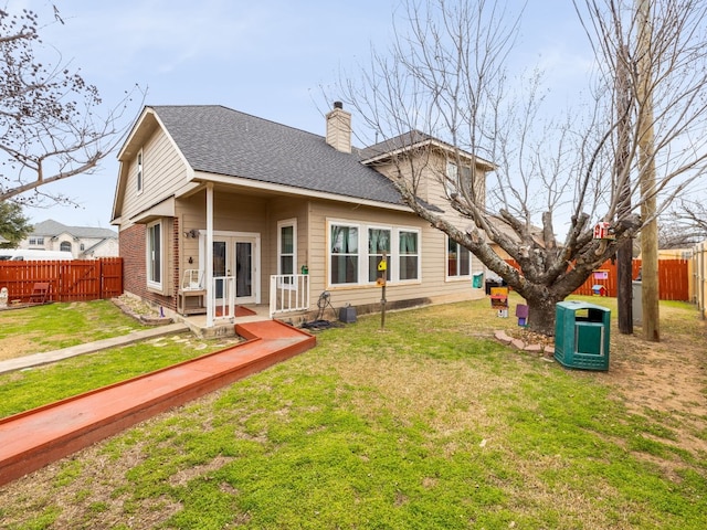 back of property with a shingled roof, a chimney, fence, and french doors