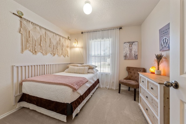 bedroom featuring light carpet, a textured ceiling, and baseboards