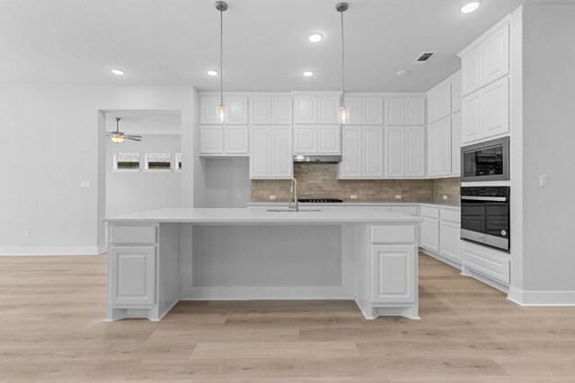 1109 Blanket Flower Dr, Georgetown, TX 78628 - kitchen with appliances with stainless steel finishes, tasteful backsplash, white cabinetry, light countertops, and recessed lighting