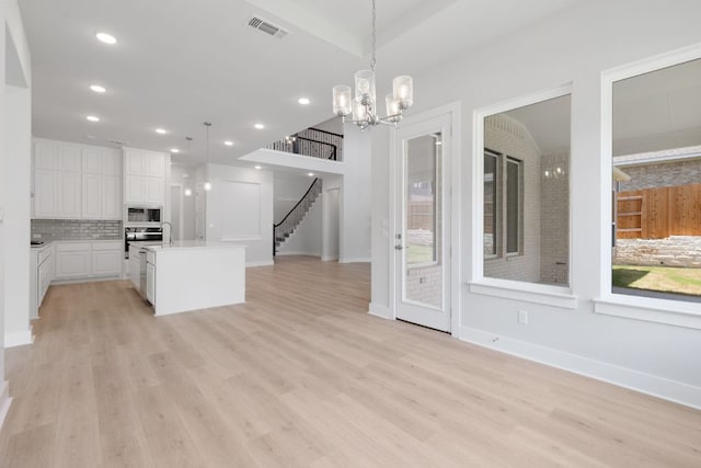 1109 Blanket Flower Dr, Georgetown, TX 78628 - kitchen with built in microwave, decorative backsplash, open floor plan, light wood-style floors, and white cabinets