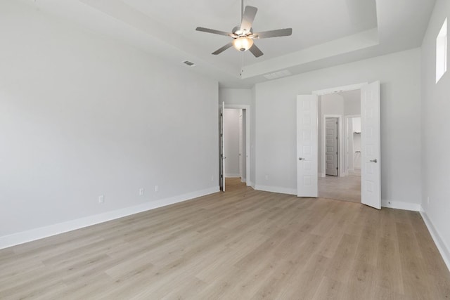 1109 Blanket Flower Dr, Georgetown, TX 78628 - unfurnished bedroom featuring light wood-style floors, a raised ceiling, and ceiling fan