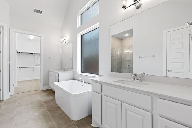 1109 Blanket Flower Dr, Georgetown, TX 78628 - full bathroom with a shower stall, two vanities, a soaking tub, high vaulted ceiling, and a spacious closet