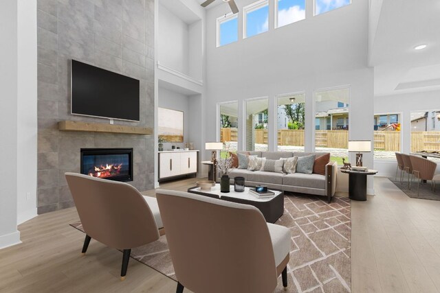 1109 Blanket Flower Dr, Georgetown, TX 78628 - living area with wood finished floors, ceiling fan, a fireplace, a high ceiling, and recessed lighting