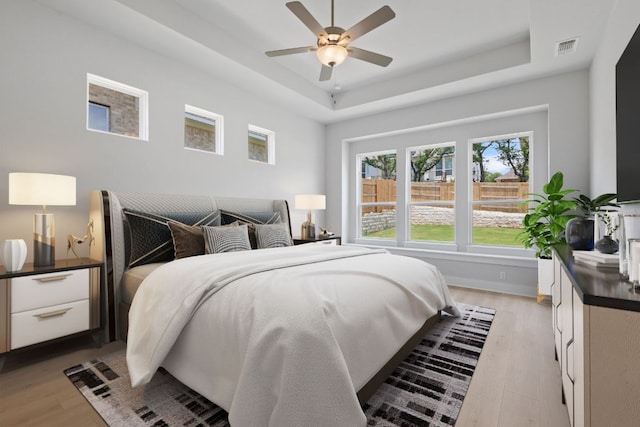 1109 Blanket Flower Dr, Georgetown, TX 78628 - bedroom featuring light wood finished floors, a raised ceiling, and ceiling fan