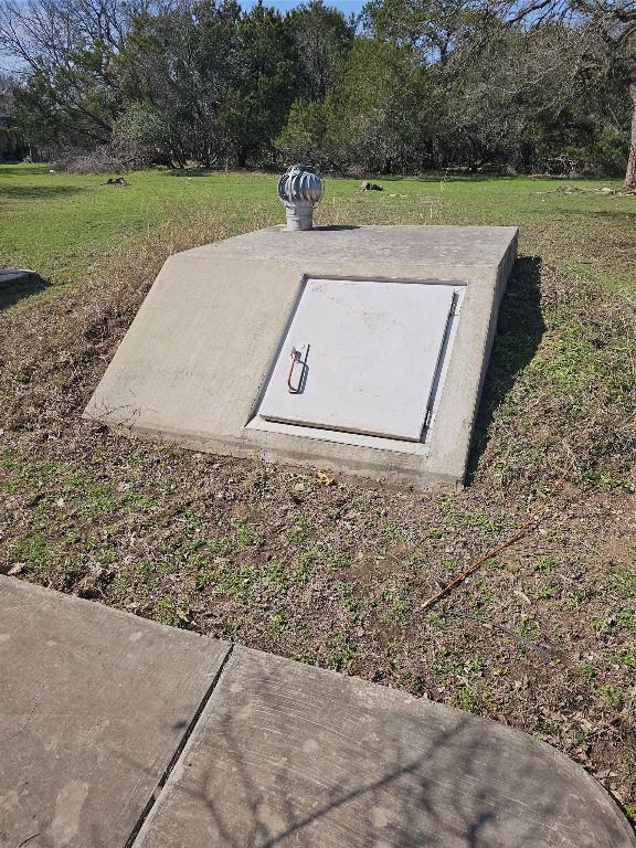 entry to storm shelter featuring a yard