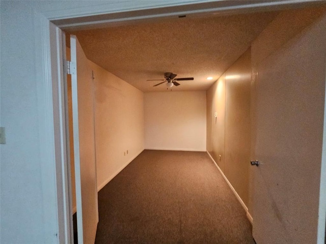 empty room featuring carpet floors, a ceiling fan, and baseboards