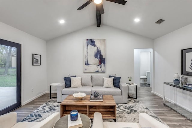 living room featuring vaulted ceiling with beams, baseboards, visible vents, and wood finished floors