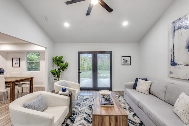 living room featuring lofted ceiling, french doors, light wood-style flooring, and recessed lighting