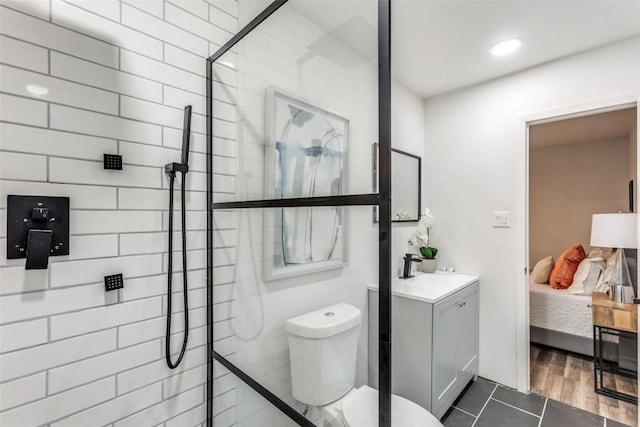 ensuite bathroom featuring toilet, ensuite bath, tile patterned floors, a tile shower, and vanity