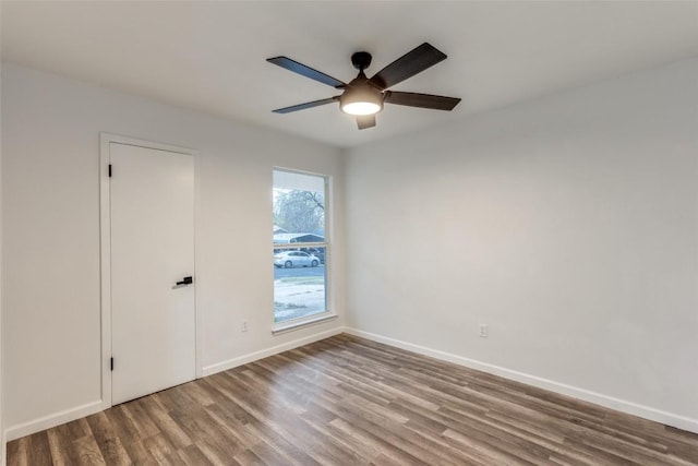 unfurnished room featuring ceiling fan, baseboards, and wood finished floors