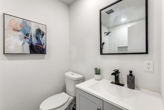 bathroom with a shower, vanity, and toilet