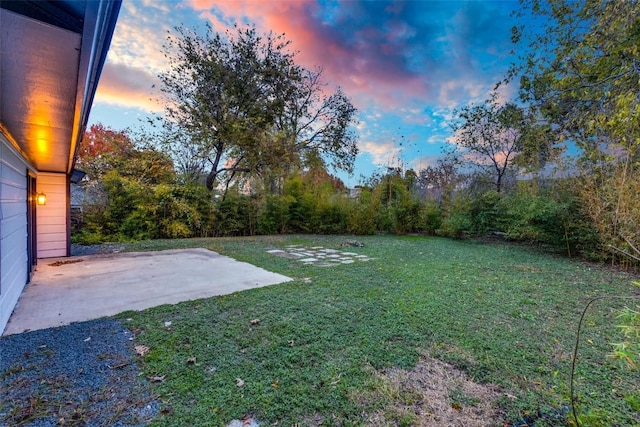 yard at dusk featuring a patio area