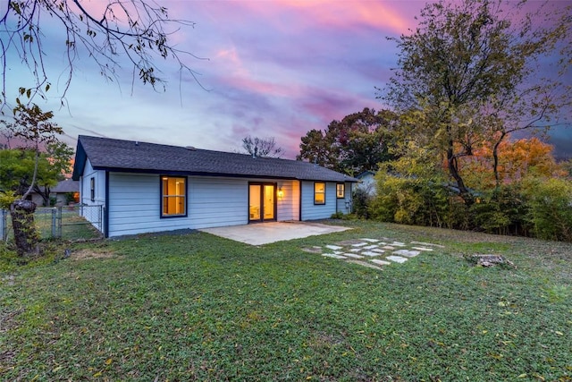 rear view of house with a gate, a patio area, a yard, and fence